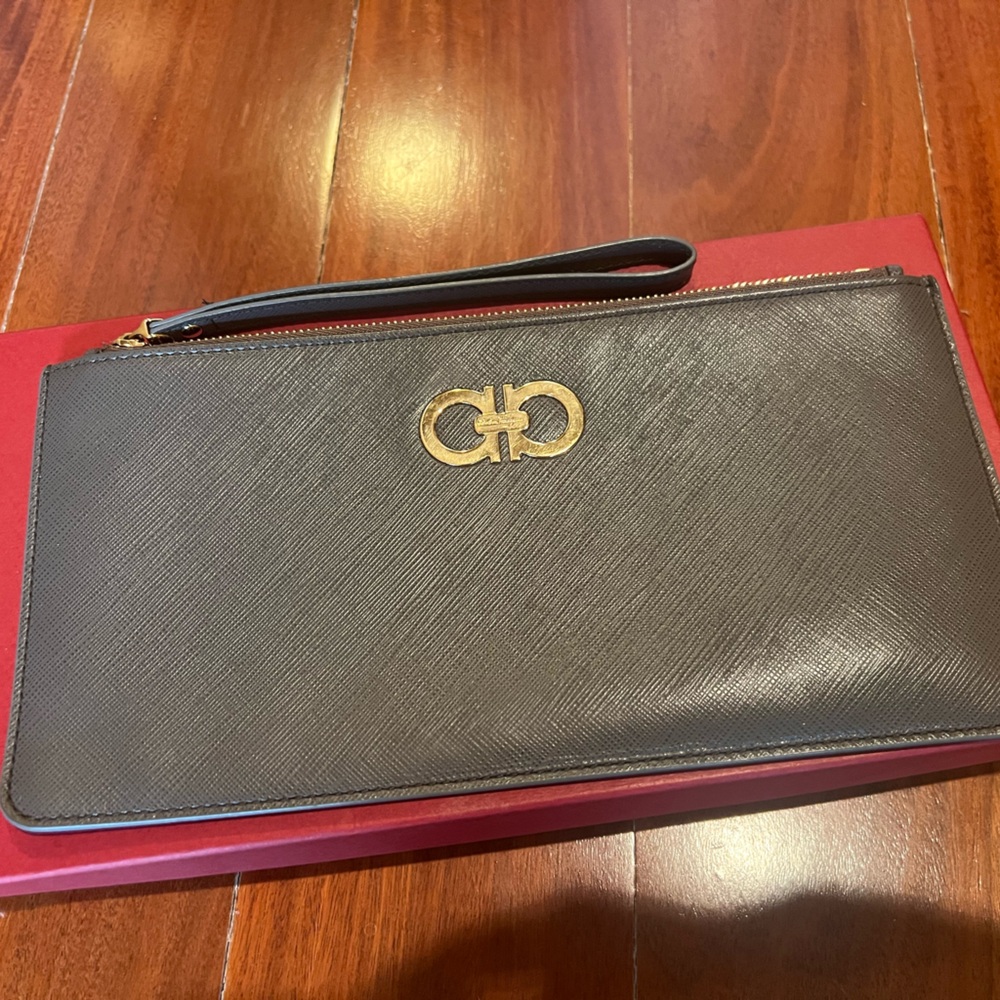 Salvatore Ferragamo gray wristlet with gold hardware.